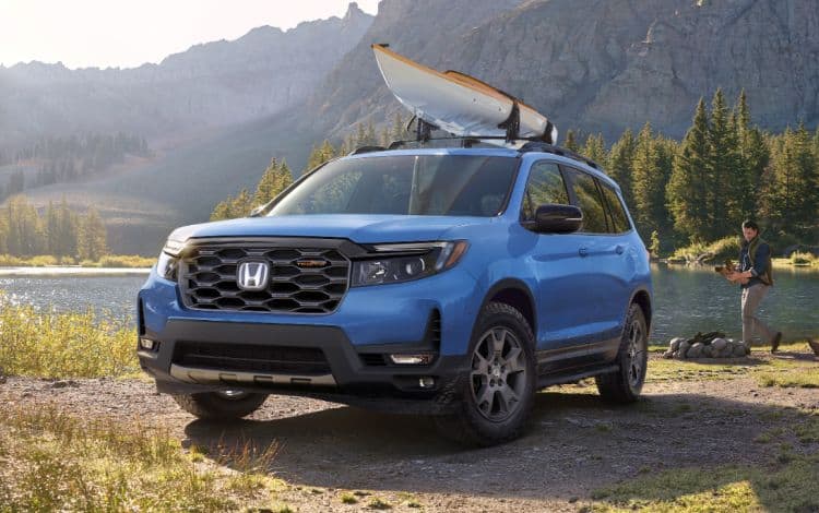 2024 Honda Passport Trailsport 3/4 front driver in Diffused Sky Blue Pearl at lakeside location parked at campsite