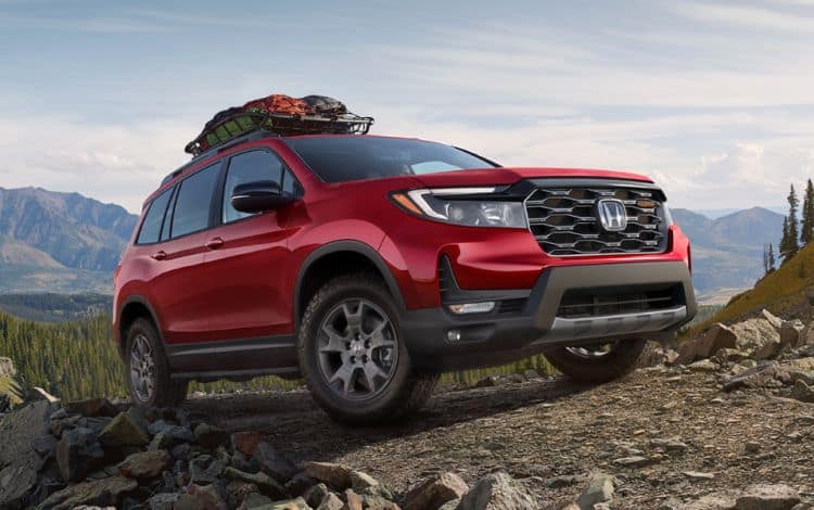 2024 Honda Passport Trailsport 3/4 front passenger in Radiant red II at rugged mountain location