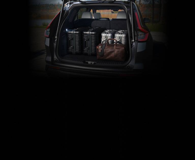 2027 Honda CR-V Sport Touring Hybrid cargo area filled with multiple suitcases (Compact Crossover SUV).