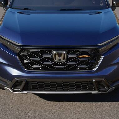 2027 Honda CR-V TrailSport Hybrid in Canyon River Blue Metallic front parked on a paved road outdoors (Compact Crossover SUV).